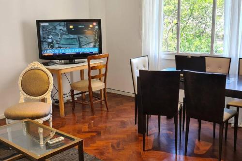 sala de estar con TV, mesa y sillas en Alquiler temporario en Recoleta Palermo en Buenos Aires