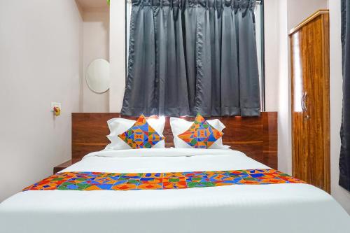 a bedroom with a large white bed with colorful pillows at FabHotel Skyline I in Méribel Village