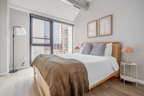 a white bedroom with a bed and a large window at Old Town 3br w gym dog run nr entertainment CHI-1004 in Chicago
