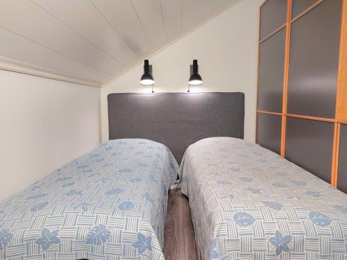 two beds sitting next to each other in a bedroom at Penthouse with a balcony in Hyvinkää