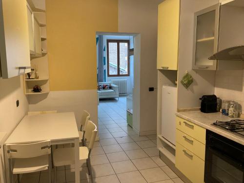 モンツァにあるSawasdee 37の黄色の壁と白いキャビネット付きのキッチン