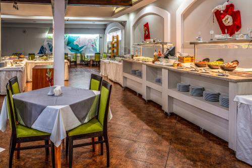 un restaurant avec une table et des chaises dans une cuisine dans l'établissement MPM Hotel Guinness, à Bansko