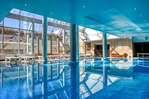 a large swimming pool with a large building with windows at MPM Hotel Guinness in Bansko