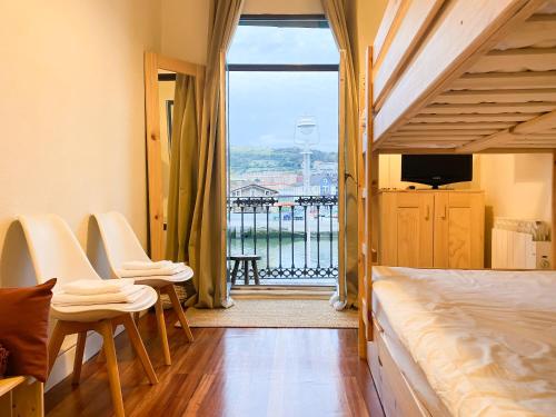 een slaapkamer met een bed en uitzicht op het water bij Refugio noruego in Bilbao