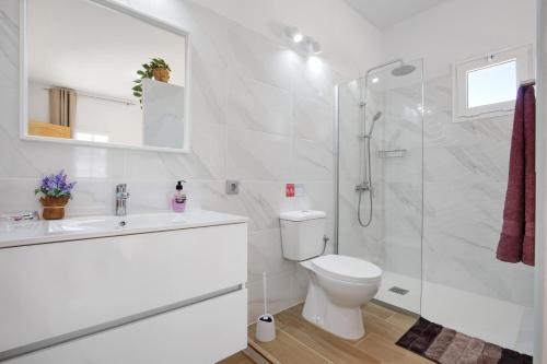 een witte badkamer met een toilet en een douche bij Apartamento El Naranjo con jacuzzi in Tarajalejo