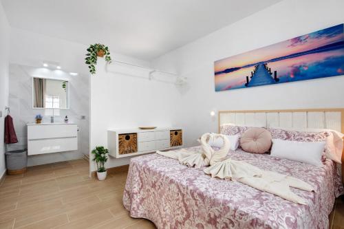 ein Schlafzimmer mit einem Bett und einem Wandgemälde in der Unterkunft Apartamento El Naranjo con jacuzzi in Tarajalejo