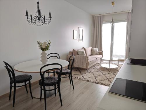 a living room with a table and chairs and a couch at Lapland Arctic Apartments in Rovaniemi