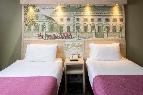 ロンドンにあるPresident Hotelの壁に絵が描かれた部屋のベッド2台