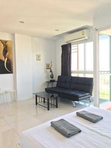 a living room with a black couch and a table at Diamond Suite in Pattaya South