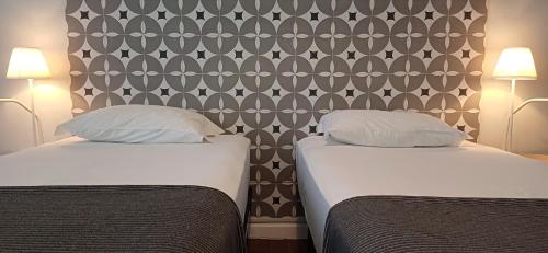 two beds sitting next to each other in a room at A Casa do Tenente in Faro
