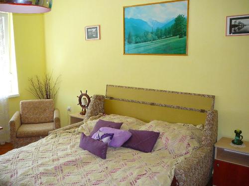 um quarto com uma cama com almofadas roxas em Großes Ferienhaus in Fonyd mit Großer Terrasse em Fonyód