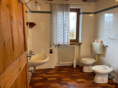 La salle de bains est pourvue d'un lavabo, de toilettes et d'une fenêtre. dans l'établissement Agri Camp Dolomiti, à Belluno