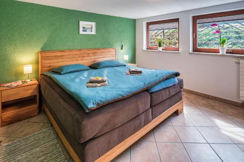ein Schlafzimmer mit einem großen Bett mit blauer Bettwäsche in der Unterkunft Ferienhaus Elbharmonie in Dresden
