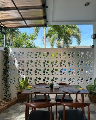 a dining room with a wall of wine glasses at Baan Rosa Bangtao Beach in Bang Tao Beach