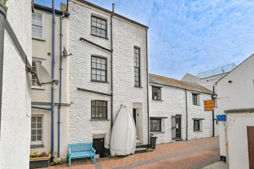 a large white building with a surfboard hanging from it at Captain's House Looe in Looe
