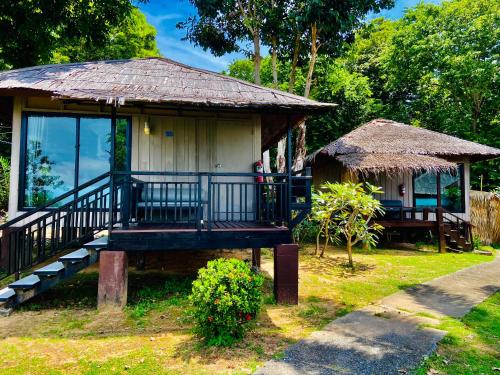 a small house with a porch and a thatch roof at HIP Seaview Resort @ Phi Phi in Phi Phi Don