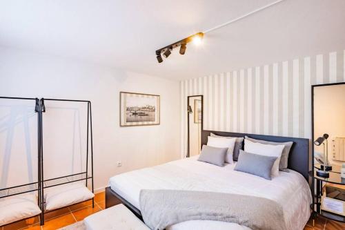 a bedroom with a large white bed with blue pillows at Gaia Elegant Retreat I in Canidelo
