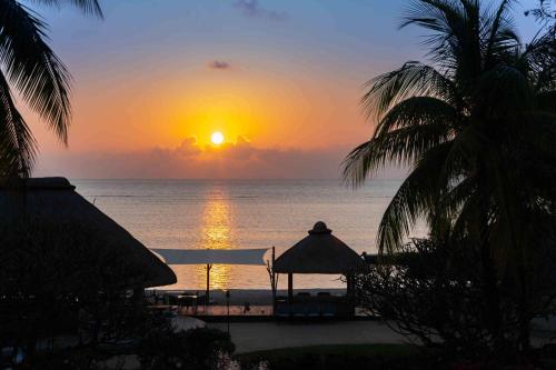 a sunset over the ocean from a resort at Hilton Mauritius Resort & Spa in Flic-en-Flac
