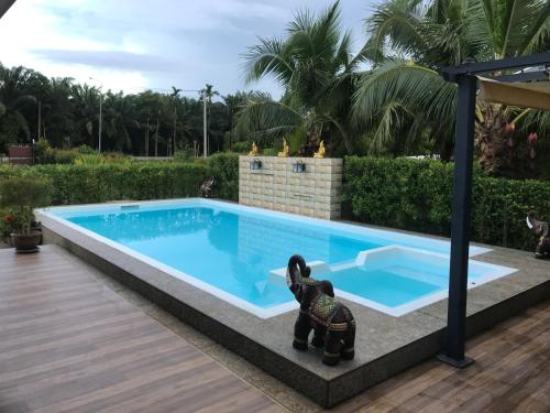 a swimming pool with a statue next to it at Pajaree and Udo‘s Happy Homestay in Trang