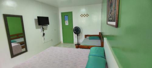 een slaapkamer met een bed en een televisie en een spiegel bij Guest House Renascer K&W in Cabo Frio