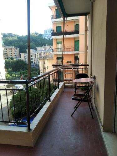 uma varanda de um edifício com uma mesa e cadeiras em Stanza matrimoniale con balcone em Gênova