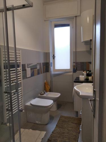 uma casa de banho com um WC, um lavatório e uma janela em Stanza matrimoniale con balcone em Gênova
