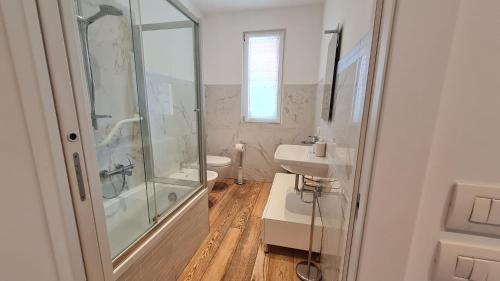 ein weißes Bad mit einer Dusche und einem Waschbecken in der Unterkunft Casa Spagnolo in Verona