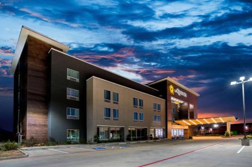 a hotel building with a cloudy sky at night at La Quinta by Wyndham Houston Cypress in Cypress