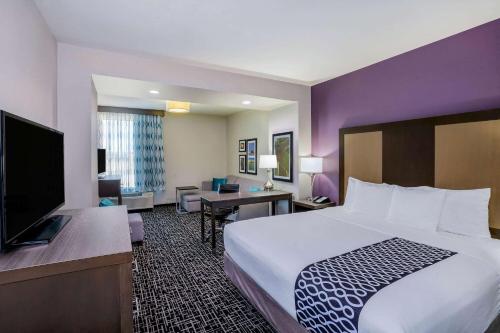 a hotel room with a bed and a flat screen tv at La Quinta by Wyndham Houston Cypress in Cypress