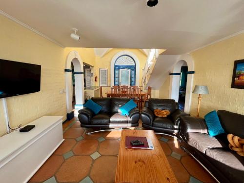 sala de estar con sofás de cuero y mesa de centro en Caribbean Estates Montego Bay 38, en Port Edward
