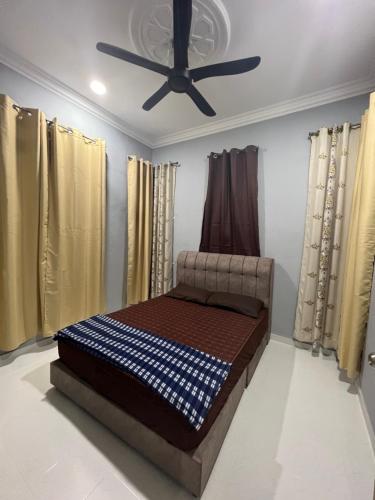 uma cama num quarto com uma ventoinha de tecto em WAJA Homestay em Kampung Raja