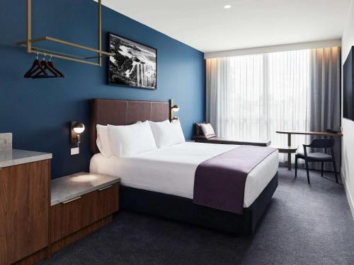 una habitación de hotel con una cama grande y una mesa en The Sebel Melbourne Ringwood, en Ringwood