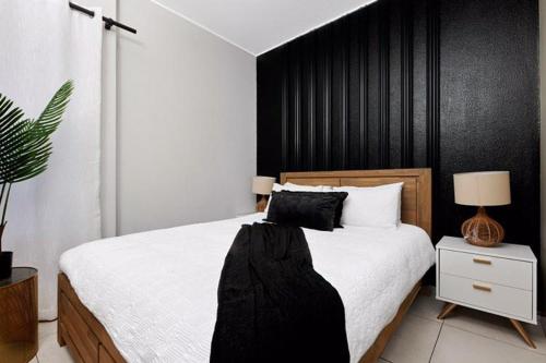 1 dormitorio con 1 cama grande y pared negra en Sunrise Rivonia One Bed en Johannesburgo