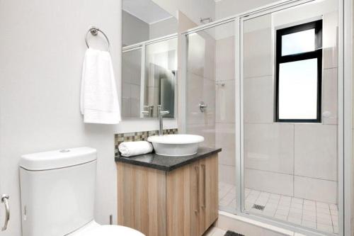 y baño blanco con lavabo y ducha. en Sunrise Rivonia One Bed en Johannesburgo