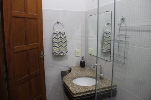 uma casa de banho com um lavatório e uma cabina de duche em vidro. em Casa Mãe da Lua em Arraial d'Ajuda