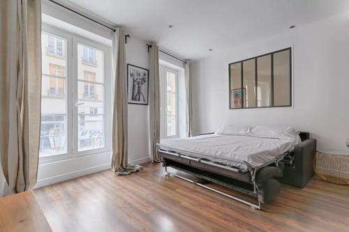 a bedroom with a bed and two large windows at SD1 - Magnifique Appartement 2BR/6P - Center Paris in Paris
