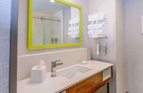 a bathroom with a sink and a yellow mirror at Hampton Inn Needles in Needles