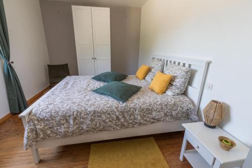 a bedroom with a white bed with colorful pillows at Gite caperot in Eyrès - Moncube
