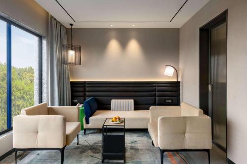 a living room with two chairs and a couch at Ramada Encore by Wyndham Bareilly Civil Lines in Bareilly