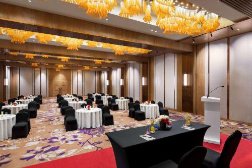 a banquet hall with tables and chairs and chandeliers at Ramada Encore by Wyndham Bareilly Civil Lines in Bareilly