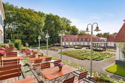 dziedziniec z drewnianymi ławkami i ogrodem w obiekcie Vienna House Easy by Wyndham Castrop-Rauxel w mieście Castrop-Rauxel