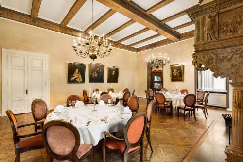 a dining room with tables and chairs and a chandelier at Vienna House Easy by Wyndham Castrop-Rauxel in Castrop-Rauxel