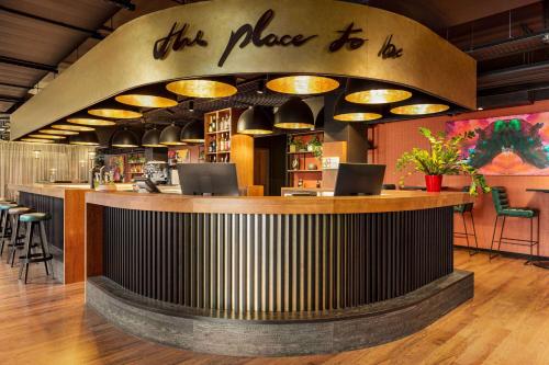 a bar with a sign that reads this place to lie at Amedia Munich Dachau, Trademark Collection by Wyndham in Dachau