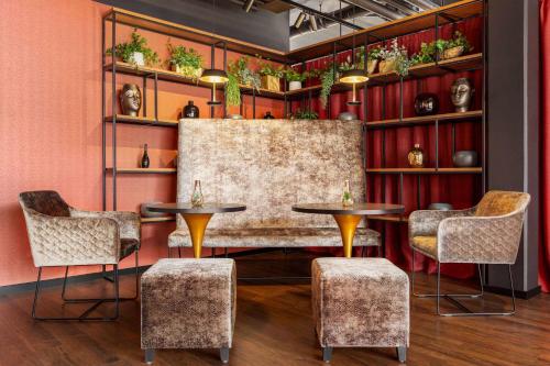 a room with two tables and chairs and shelves with plants at Amedia Munich Dachau, Trademark Collection by Wyndham in Dachau