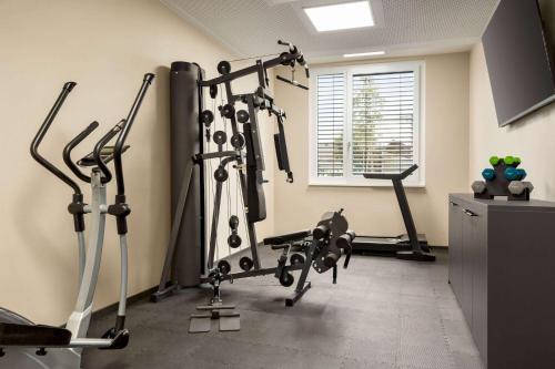 a gym with several tread machines in a room at Amedia Munich Dachau, Trademark Collection by Wyndham in Dachau