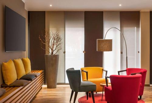 a waiting room with colorful chairs and a table at Amedia Hotel Siegen City, Trademark Collection by Wyndham in Siegen