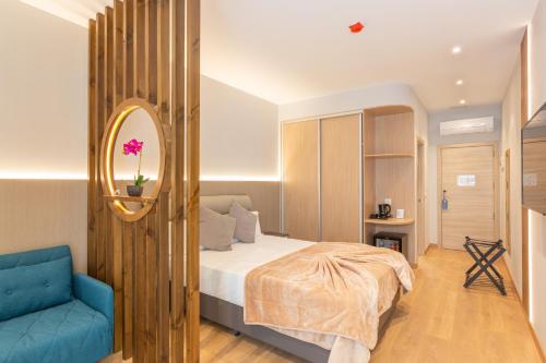 ein Schlafzimmer mit einem Bett und einem blauen Stuhl in der Unterkunft Hotel Casa Lili in Jávea