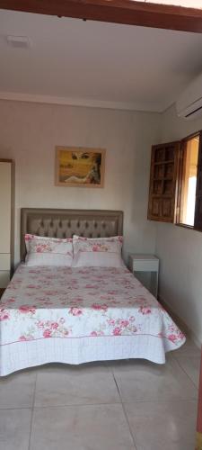 um quarto com uma cama grande e uma colcha floral em Cactu's em Cabedelo