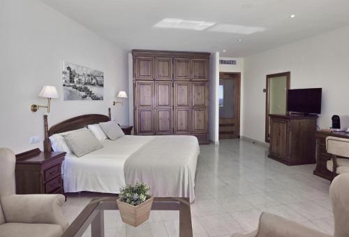 a bedroom with a large bed and a television at Sunway Playa Golf & Spa Sitges in Sitges