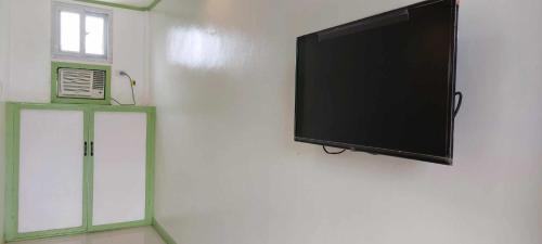 einen Flachbild-TV, der an einer Wand hängt in der Unterkunft Casa Santuaria in Itaytay